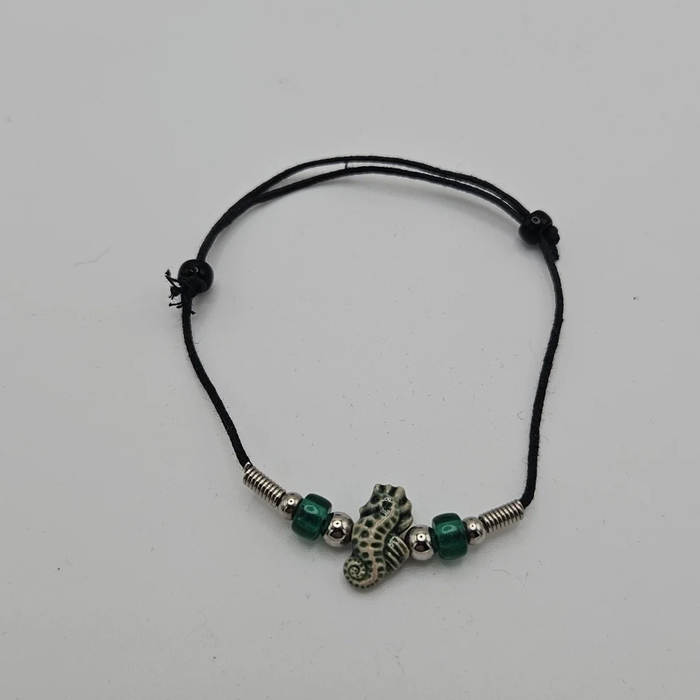 black slider bracelet with green and cream seahorse bead